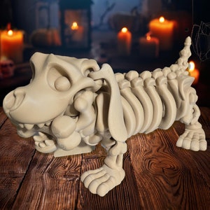 May include: A beige skeletal dog figurine with a large head and a toothy grin. The dog is posed in a walking position with its front legs raised. The figurine is set against a dark background with a blurred image of a moon and spiderwebs.