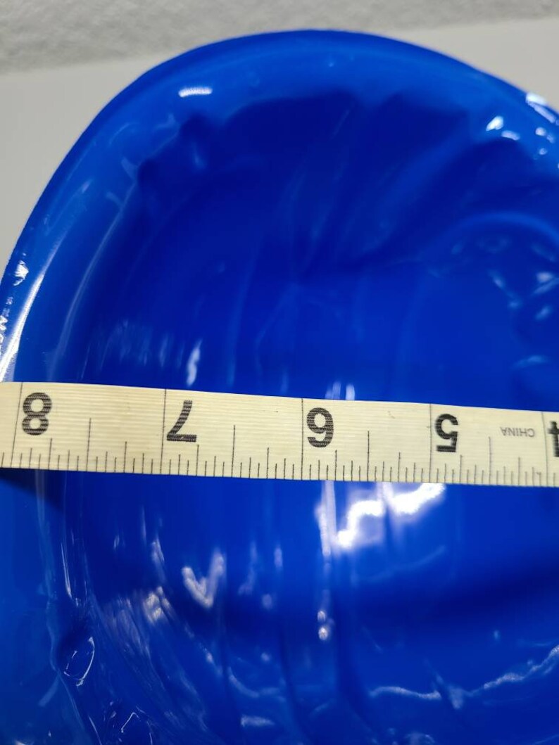 May include: A bright blue ceramic bowl with a wavy, textured surface. The bowl is 9 inches in diameter.