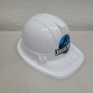 May include: White plastic construction hard hat with a blue and black Jurassic World logo.