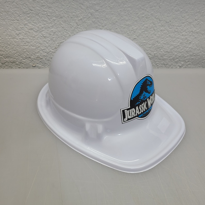 May include: White plastic construction hard hat with a blue and black Jurassic World logo.