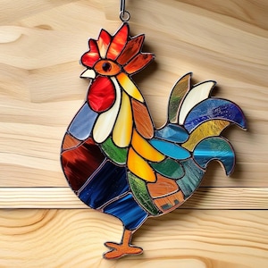 May include: A colourful stained glass rooster with a red comb and wattle, blue, yellow, and green feathers, and a black and blue tail. The rooster is hanging from a metal hook.