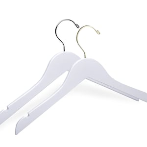May include: Two white wooden hangers with metal hooks. One hook is silver and the other is gold.