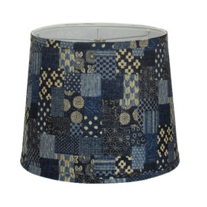 May include: A blue and cream patterned lampshade with a patchwork design.