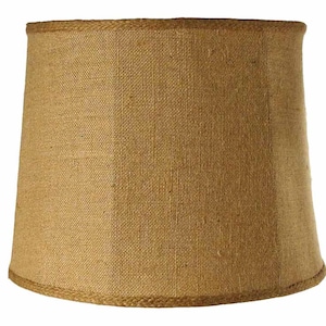 May include: A brown, round lampshade made of burlap with a woven texture. The lampshade has a simple design and a natural, rustic look.