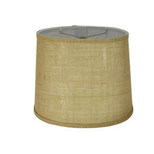 May include: A beige burlap lampshade with a cylindrical shape. The lampshade has a light gray interior and a metal frame. The burlap material has a woven texture. The lampshade is designed for use with a lamp base.