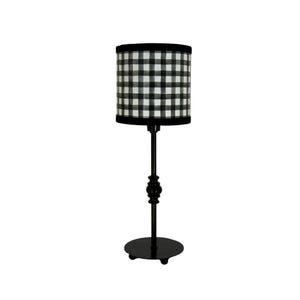 Op de afbeelding: Zwart-wit geblokte lampenkap met een zwarte metalen voet en een ronde basis. De lamp heeft een zwarte knop.