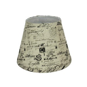 May include: A beige lampshade with a black and white print of French script and postage stamps. The lampshade is a cone shape.