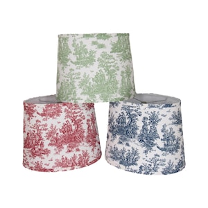 May include: Three lampshades with a toile pattern. The lampshades are white with a green, red, and blue toile pattern.