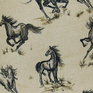 Op de afbeelding: Een herhalend patroon van rennende paarden in grijstinten en zwart op een beige achtergrond. De paarden zijn afgebeeld in een aquarel stijl, met vloeiende manen en staarten. Het ontwerp bevat kleine plukjes gras.