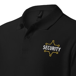 Könnte beinhalten: Schwarzes Poloshirt mit einem gelben Stern und dem Wort "SECURITY" auf der linken Brust gestickt.