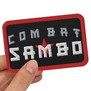Może przedstawiać: Naszywka haftowana w kolorze czerwonym i czarnym z napisem "COMBAT SAMBO" i czerwoną gwiazdą.