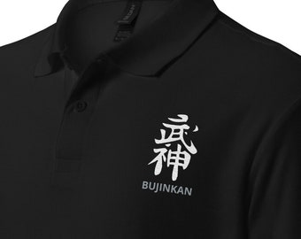 May include: Black polo shirt with a white kanji character and the text "BUJINKAN" embroidered on the left chest.