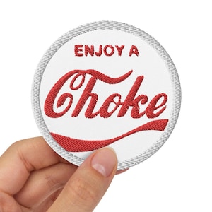 Peut inclure: Patch rond blanc avec un motif brodé rouge qui dit "Enjoy a Choke" dans une police de caractères stylisée.