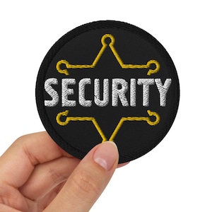May include: A black round patch with a yellow five-pointed star and the word "SECURITY" in white lettering.
