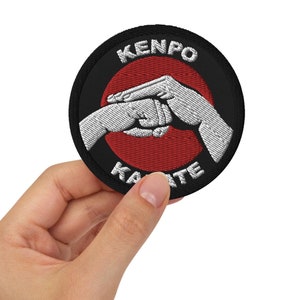 May include: A black and red embroidered patch with the text "Kenpo Karate" and a white image of two hands clasped together.