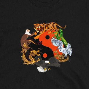 May include: Black t-shirt featuring a yin yang symbol surrounded by a tiger, monkey, dragon, eagle, and a crane.