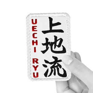 May include: White embroidered patch with the text "Uechi-ryu" in red and the Japanese characters for "Uechi-ryu" in black.