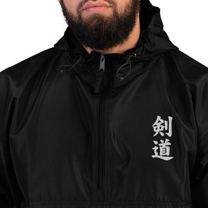 May include: Black hooded jacket with a zipper closure and a white embroidered design that says "剣道" on the front.