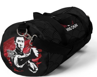 May include: Black duffel bag with a red and white illustration of a man in a fighting stance. The bag has a black and white wave pattern and the text "Wing Chun" on the side.