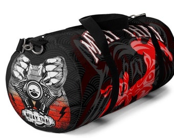 May include: Black and red travel duffel bag with a graphic of a motorcycle engine and the words "Muay Thai" printed on the side.