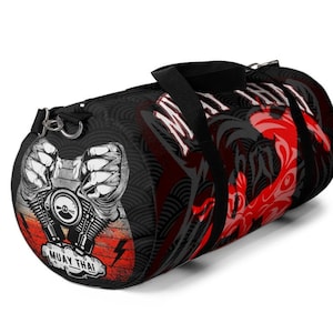 Puede incluir: Bolsa de viaje de lona negra y roja con un gráfico de un motor de motocicleta y las palabras "Muay Thai" impresas en el lateral.