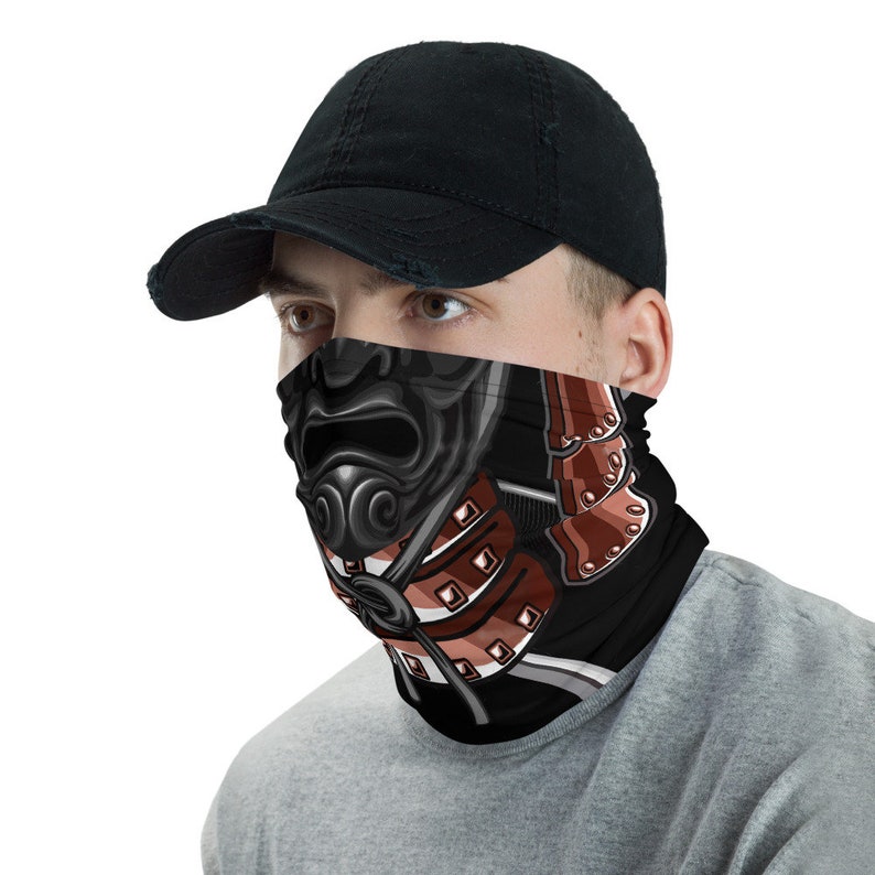 Pode incluir: Uma m&aacute;scara facial preta com um design de samurai vermelho e branco. A m&aacute;scara apresenta um capacete de samurai com uma m&aacute;scara facial amea&ccedil;adora e uma placa de peito com padr&atilde;o vermelho e branco.