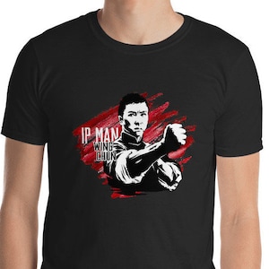 May include: Black t-shirt with a white silhouette of Bruce Lee in a fighting pose. The text "IP MAN WING CHUN" is printed in white on the shirt.