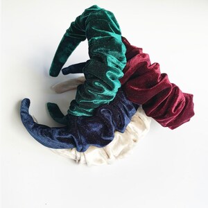 May include: Set of four velvet hair scrunchies in green, navy blue, burgundy, and cream colors. The scrunchies are made of soft, stretchy velvet and are perfect for adding a touch of elegance to any hairstyle.