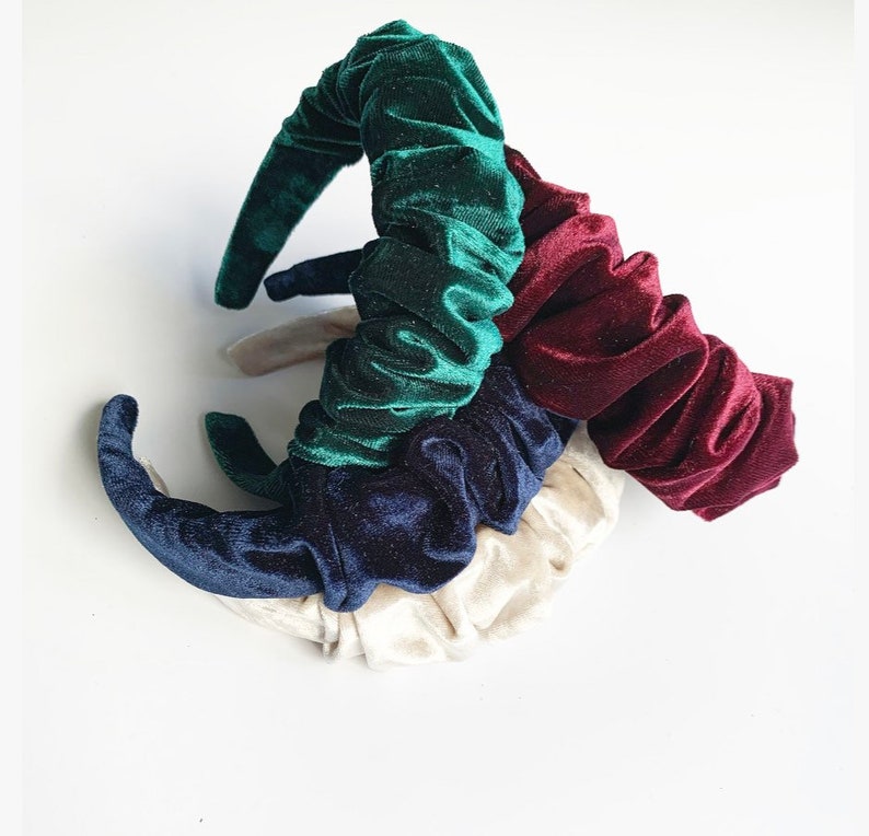 May include: Set of four velvet hair scrunchies in green, navy blue, burgundy, and cream colors. The scrunchies are made of soft, stretchy velvet and are perfect for adding a touch of elegance to any hairstyle.