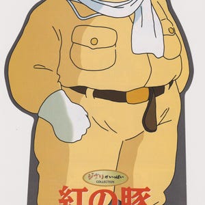Peut inclure: Une d&eacute;coupe promotionnelle d'un personnage cochon portant une combinaison de vol beige, une &eacute;charpe blanche et des lunettes d'aviateur. Le texte inclut "紅の豚", "宮崎駿" et "2002年3月8日 DVD2枚組で新発売!!". Le personnage a une moustache noire et porte des lunettes de soleil.