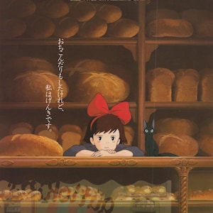 以下が含まれることがあります： アニメ映画「魔女の宅急便」のポスター。赤いリボンをつけた赤い髪の少女が、パンでいっぱいのカウンターの後ろから外を見ている。ポスターのテキストには「魔女の宅急便」と「つまずいたりもしたけど、げんきです。」と書かれている。