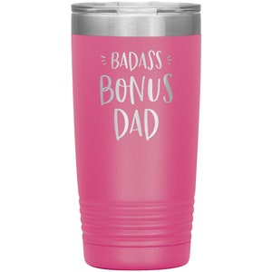 May include: Pink stainless steel tumbler with a silver inscription that reads "Badass Bonus Dad".