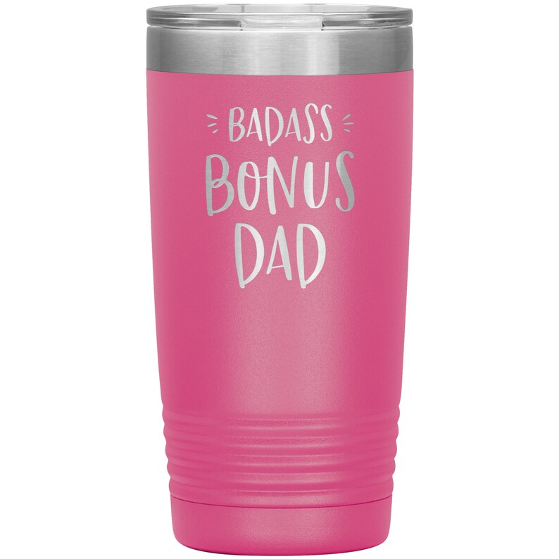 May include: Pink stainless steel tumbler with a silver inscription that reads "Badass Bonus Dad".