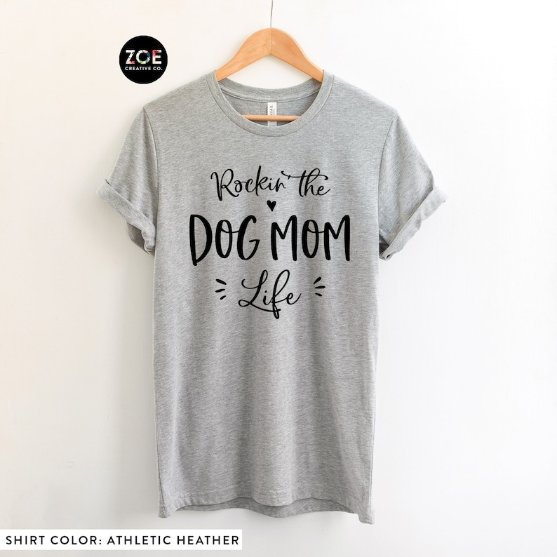 May include: Gray t-shirt with black text that reads "Rockin' the Dog Mom Life" with a small heart between "Rockin'" and "the".