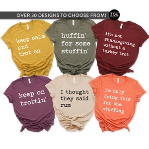 May include: Six different Thanksgiving themed t-shirts with various colours and designs. The shirts feature text such as "keep calm and trot on", "huffin' for some stuffin'", "it's not Thanksgiving without a turkey trot", "keep on trottin'", "I thought they said rum", and "I'm only doing this for the stuffing".