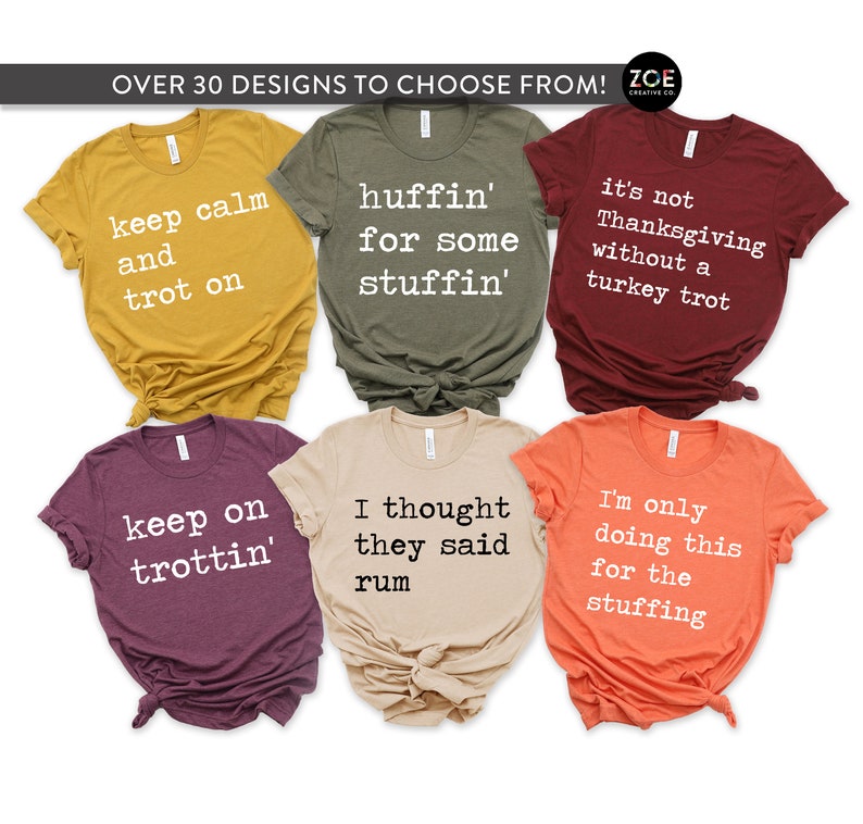 May include: Six different Thanksgiving themed t-shirts with various colours and designs. The shirts feature text such as "keep calm and trot on", "huffin' for some stuffin'", "it's not Thanksgiving without a turkey trot", "keep on trottin'", "I thought they said rum", and "I'm only doing this for the stuffing".