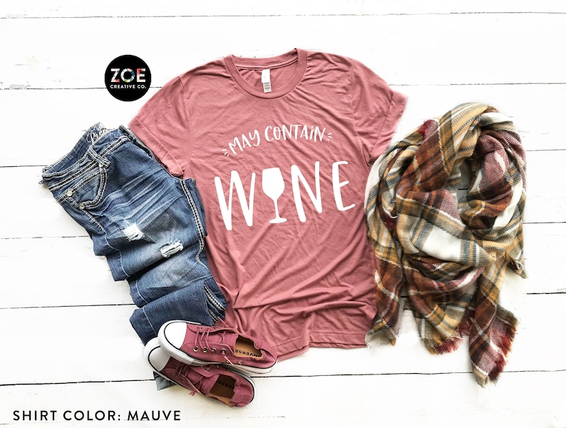 May include: Mauve t-shirt with the text "May Contain Wine" and a white wine glass graphic.
