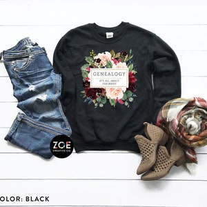 Peut inclure: Sweat-shirt noir avec un motif floral et le texte "Genealogie C'est tout ce qui compte les racines".