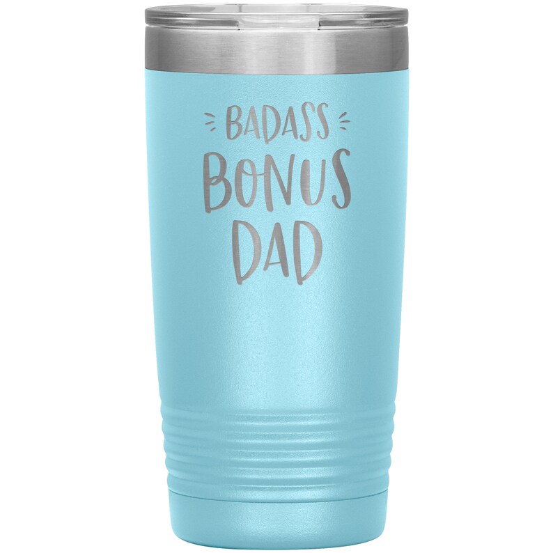 May include: A light blue stainless steel tumbler with a silver lid. The tumbler has the text "BADASS BONUS DAD" engraved on the front.