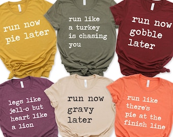 May include: Six different t-shirts with Thanksgiving-themed text printed on them. The shirts are in various colors, including mustard yellow, green, maroon, beige, and orange.