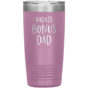 May include: A purple stainless steel tumbler with the text "Badass Bonus Dad" in white lettering.