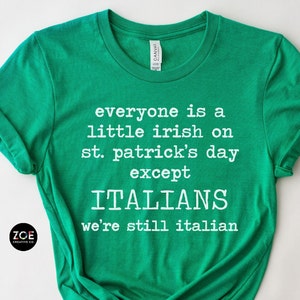 May include: A green t-shirt with white text that reads "everyone is a little irish on st. patrick's day except ITALIANS we're still italian." The shirt has a crew neck and short sleeves. The brand logo is in the bottom left corner.