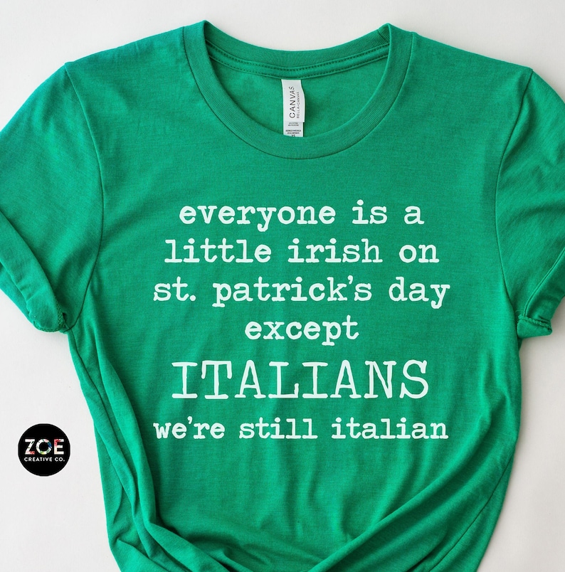 May include: A green t-shirt with white text that reads "everyone is a little irish on st. patrick's day except ITALIANS we're still italian." The shirt has a crew neck and short sleeves. The brand logo is in the bottom left corner.