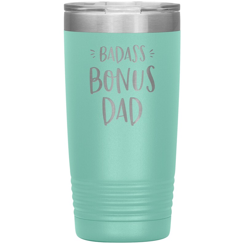 May include: A teal stainless steel tumbler with a silver lid. The tumbler has the text "BADASS BONUS DAD" engraved on the front.