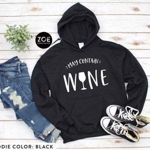 K&ouml;nnte beinhalten: Schwarzer Hoodie mit wei&szlig;em Text "May Contain Wine" und einer Weinglasgrafik.