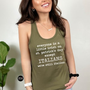 May include: Olive green tank top with white text that reads "everyone is a little irish on st. patrick's day except ITALIANS we're still italian". The tank top has a racerback style.