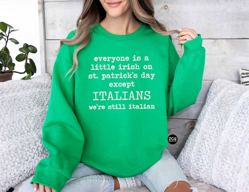 May include: A bright green sweatshirt with white text that reads "everyone is a little irish on st. patrick's day except ITALIANS we're still italian". The sweatshirt is a crew neck style.