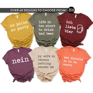 May include: Six t-shirts in different colours, each featuring a unique white text design. The shirts display phrases such as "no polka no party", "life is too short to drink bad beer", and "ich liebe bier".
