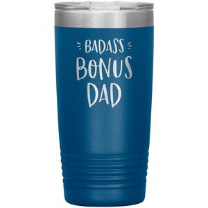 May include: A blue stainless steel tumbler with the text "Badass Bonus Dad" in white lettering.