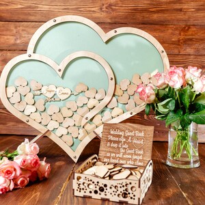 K&ouml;nnte beinhalten: Holz-G&auml;stebuch in Herzform mit einem Schild mit der Aufschrift "Wedding Guest Book Please sign a Heart & drop it into the Guest Book so we will never forget our loved ones who come".